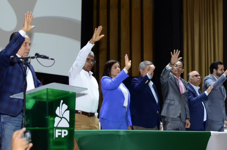 El expresidente Leonel Fernández junto a Rafael Paz y Rafael Alburquerque levantando las manos en la juramentación de las directivas del Distrito Nacional.