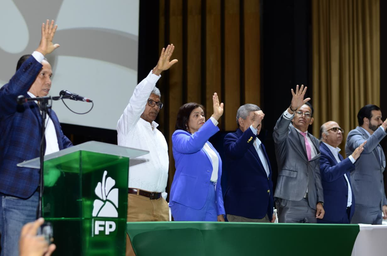 El expresidente Leonel Fernández junto a Rafael Paz y Rafael Alburquerque levantando las manos en la juramentación de las directivas del Distrito Nacional.