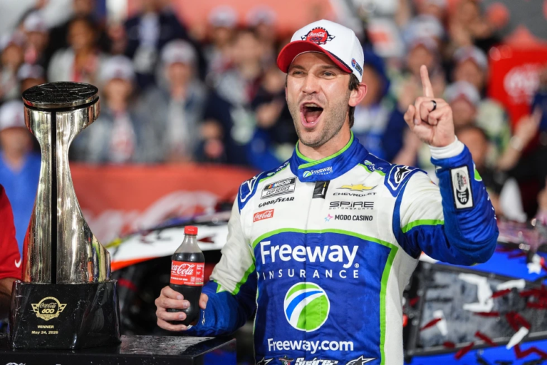 El piloto mexicano Daniel Suárez celebrando emocionado junto a su auto bajo la lluvia tras ganar el Coca-Cola 600 en Charlotte.