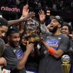 El pívot dominicano Karl-Anthony Towns sonríe eufórico junto a Jalen Brunson y sus compañeros de los Knicks de Nueva York mientras levantan el trofeo de campeones de la Conferencia Este en el tabloncillo.