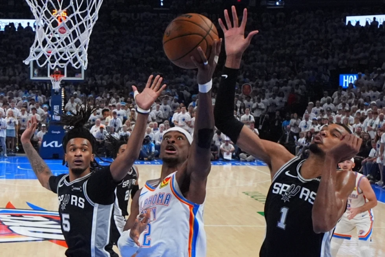 Shai Gilgeous-Alexander penetra con fuerza hacia el aro eludiendo la defensa de Victor Wembanyama en el Paycom Center.