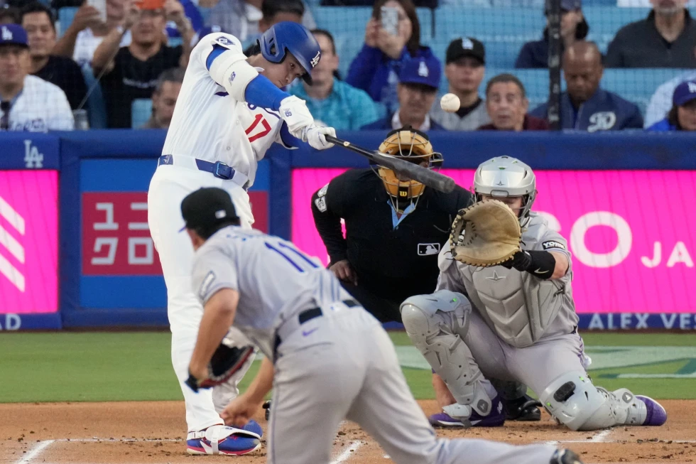 Vista de acción donde Shohei Ohtani (17) conecta un cuadrangular solitario ante el abridor de los Rockies, Tomoyuki Sugano, mientras el receptor Hunter Goodman sigue la trayectoria de la pelota en el Dodgers Stadium.