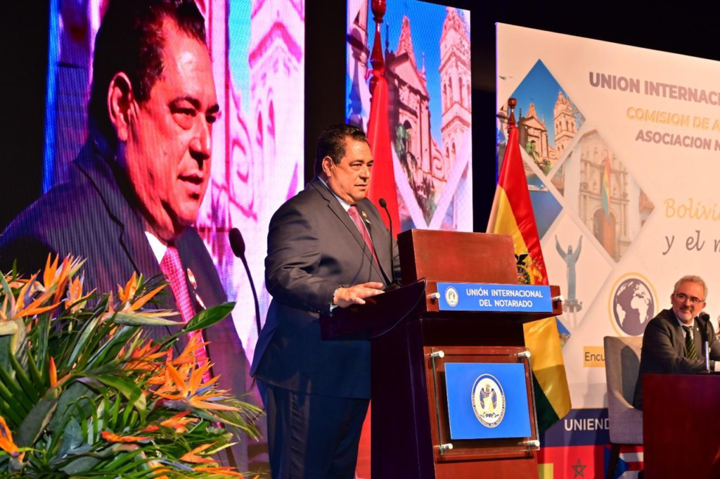 El abogado dominicano Jhon Richard Paniagua Feliz levanta su mano derecha para tomar juramento ante directivos de la Unión Internacional del Notariado Latino.