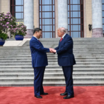 El presidente Donald Trump gesticula junto a un serio Xi Jinping durante el desfile militar de honor en el Gran Salón del Pueblo en Pekín.