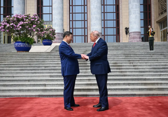 El presidente Donald Trump gesticula junto a un serio Xi Jinping durante el desfile militar de honor en el Gran Salón del Pueblo en Pekín.