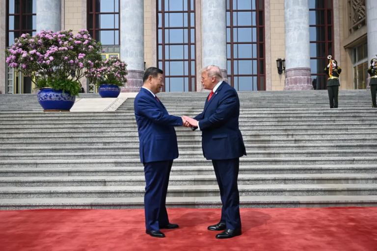El presidente Donald Trump gesticula junto a un serio Xi Jinping durante el desfile militar de honor en el Gran Salón del Pueblo en Pekín.