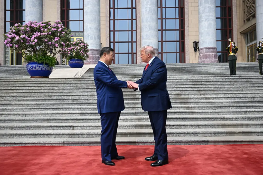 El presidente Donald Trump gesticula junto a un serio Xi Jinping durante el desfile militar de honor en el Gran Salón del Pueblo en Pekín.