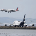 Avión de American Airlines aterrizando junto a aeronave de Lufthansa en pista aeroportuaria.