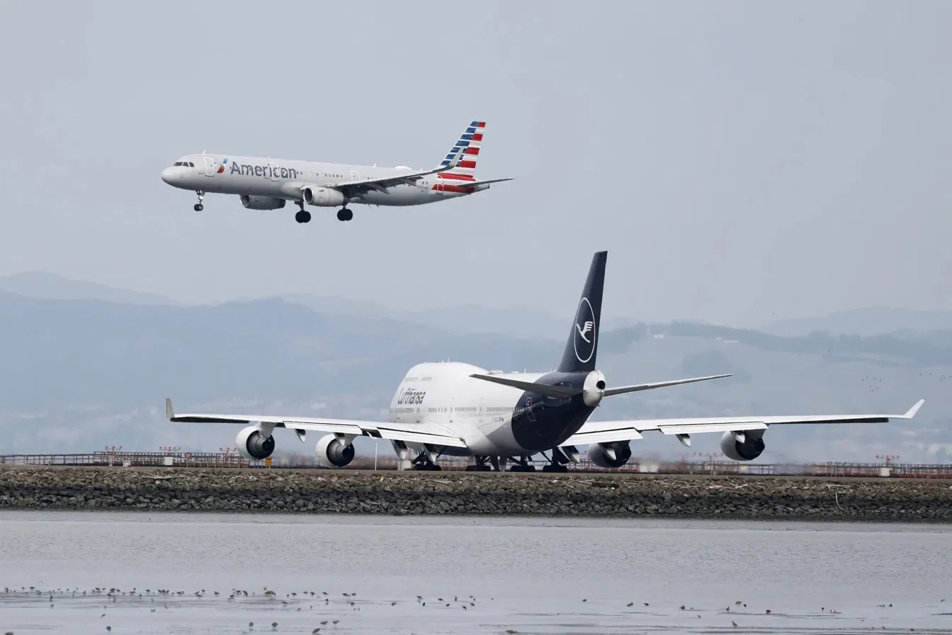 Avión de American Airlines aterrizando junto a aeronave de Lufthansa en pista aeroportuaria.