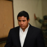 Adán Cáceres Silvestre, exdirector del Cuerpo de Seguridad Presidencial (Cusep), sale cabizbajo de la sala de audiencias del Primer Tribunal Colegiado del Distrito Nacional tras ser condenado a 20 años de prisión en el caso Coral, el 16 de junio de 2026.