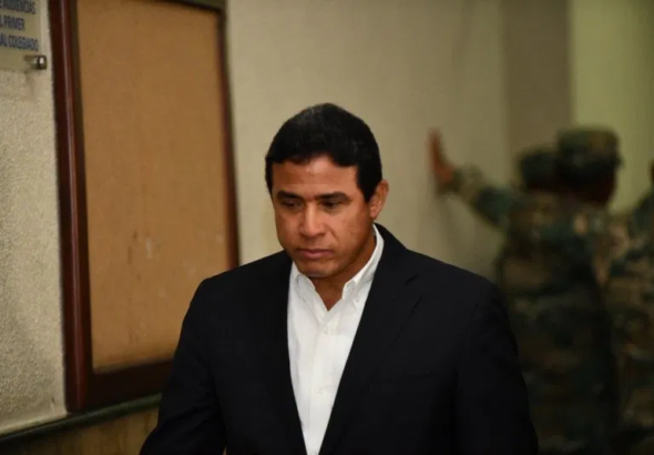 Adán Cáceres Silvestre, exdirector del Cuerpo de Seguridad Presidencial (Cusep), sale cabizbajo de la sala de audiencias del Primer Tribunal Colegiado del Distrito Nacional tras ser condenado a 20 años de prisión en el caso Coral, el 16 de junio de 2026.