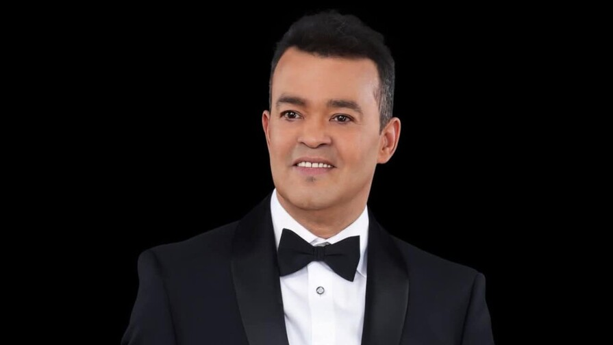 Nacido en San José de las Matas, Alejandro Wigberto Bueno López (nombre real del artista) se convirtió en un pilar de la época dorada del merengue en los años 80. Su voz sumamente afinada le permitió navegar con el mismo éxito en la bachata, la salsa y las baladas románticas. Canciones como "Jardín prohibido", "Colegiala" y "Esa mujer" forman parte imborrable del cancionero popular dominicano.