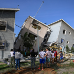 Vista de rescatistas y ciudadanos frente a edificios y viviendas gravemente dañadas tras el sismo en Catia La Mar, Venezuela.