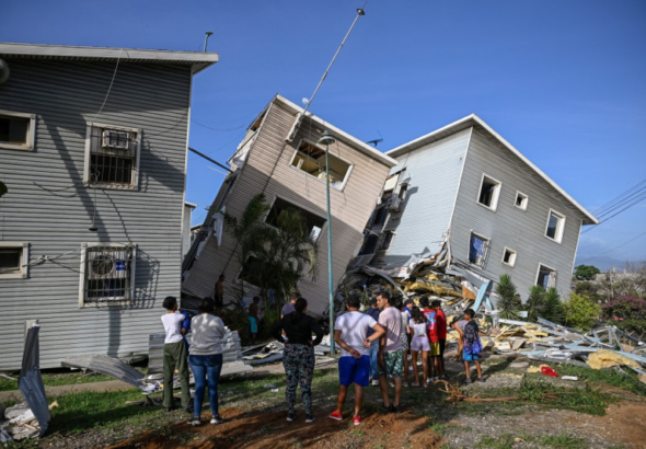 Vista de rescatistas y ciudadanos frente a edificios y viviendas gravemente dañadas tras el sismo en Catia La Mar, Venezuela.