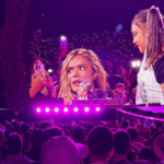 La cantante urbana Karol G sonríe en el escenario durante su gira mundial TropiTour.
