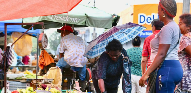 Comerciantes y vendedores ambulantes trabajando bajo el sol intenso durante la ola de calor en Santo Domingo.