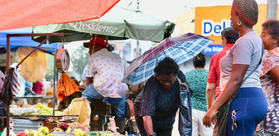 Comerciantes y vendedores ambulantes trabajando bajo el sol intenso durante la ola de calor en Santo Domingo.