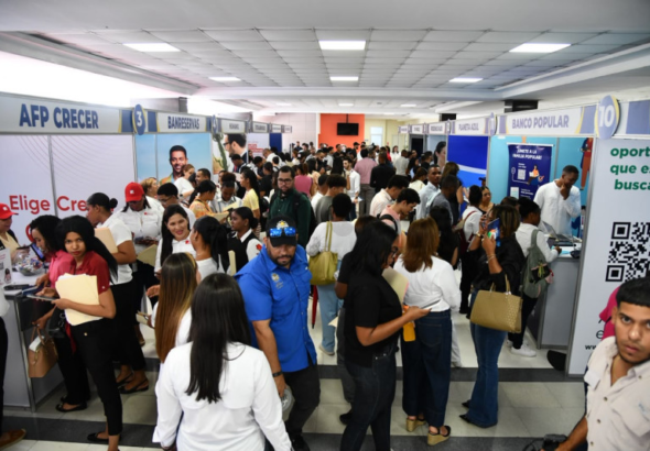 Cientos de jóvenes haciendo fila con currículums en mano durante la feria de empleo en el campus de la PUCMM
