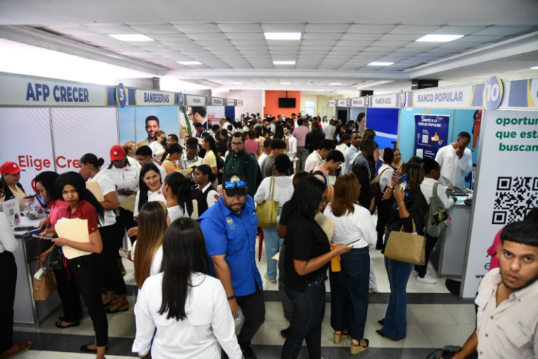 Cientos de jóvenes haciendo fila con currículums en mano durante la feria de empleo en el campus de la PUCMM
