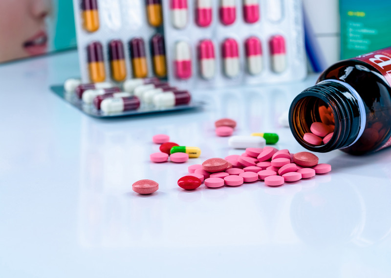 Frascos y cápsulas de medicamentos cardiovasculares que ilustran los avances terapéuticos en el control del colesterol perjudicial.