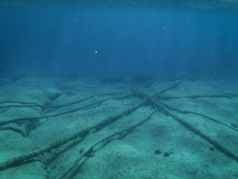 Tendido de cables submarinos de fibra óptica de alta tecnología en el fondo del océano para la interconexión global de datos.