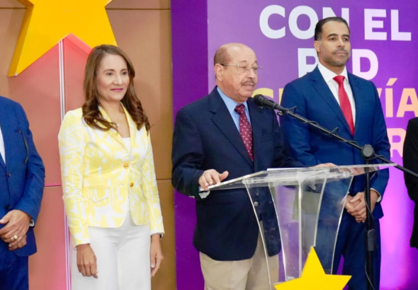 El dirigente político Juan Temístocles Montás hablando frente a los micrófonos durante una rueda de prensa oficial en la casa nacional del Partido de la Liberación Dominicana.
