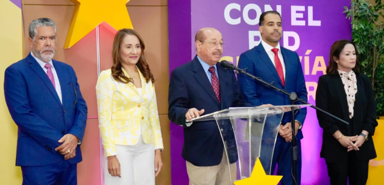 El dirigente político Juan Temístocles Montás hablando frente a los micrófonos durante una rueda de prensa oficial en la casa nacional del Partido de la Liberación Dominicana.