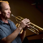 El trompetista de jazz Chris Kase califica la música con inteligencia artificial como un engaño y critica las fallas en la formación musical actual.