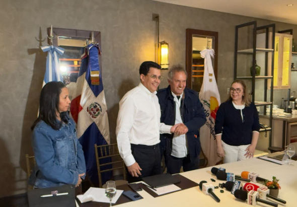 David Collado y Daniel Scioli firmando acuerdo de turismo deportivo en la FIT Buenos Aires