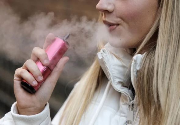 Personas expuestas al vapor de cigarrillos electrónicos en la terraza de un restaurante