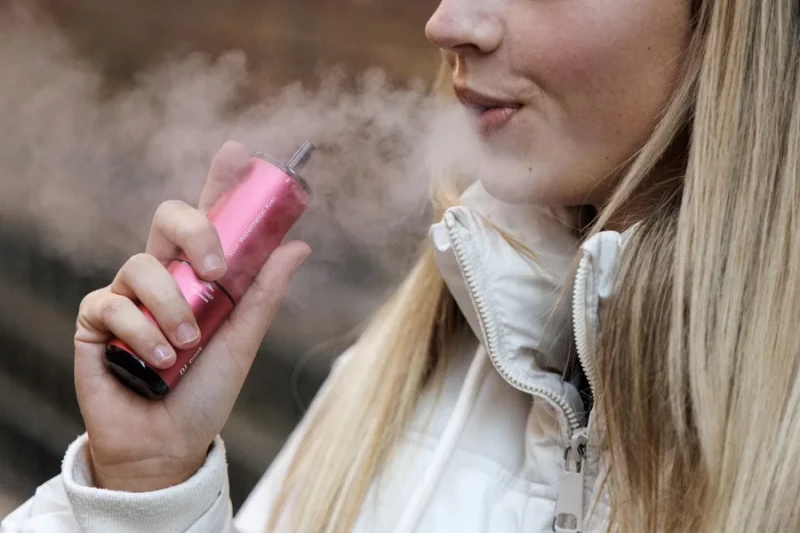 Personas expuestas al vapor de cigarrillos electrónicos en la terraza de un restaurante